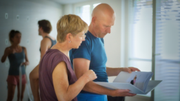 Zwei Teilnehmer:innen der Yogalehrer Ausbildung 2022 von the yoga place in Zürich schauen in das Handbuch.