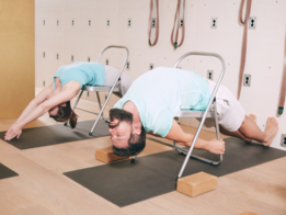 Teilnehmer üben Rückbeugen mit dem Yogastuhl