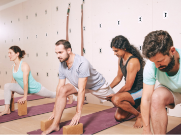 Joey korrigiert einen Teilnehmer in einer Yogastellung