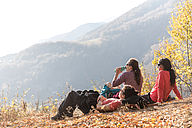 Tanja und Joey von the yoga place Zürich sitzen am Boden und geniessen die Aussicht beim Wandern im Malcantone Tessin